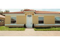 Tan house with a red tile roof and white accents at 1736 Pacific Rd, Kissimmee, FL 34759