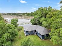 Aerial view of a charming ranch house with a pond in the backyard at 10 Locust Run Crse, Ocala, FL 34472