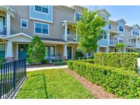 Townhouse exterior with manicured lawn and landscaping at 590 Piazza Pt, Oviedo, FL 32765