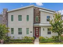 Modern two-story home with stone accents and red door at 2874 Stanza Ct, Kissimmee, FL 34746