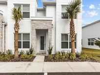 Modern two-story home with stone accents and lush landscaping at 17409 Hidden Forest Dr, Clermont, FL 34714