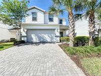 Two-story house with gray brick driveway and lush landscaping at 8914 Zurich Ln, Kissimmee, FL 34747
