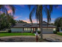 House exterior at dusk, showcasing landscaping and driveway at 1333 Clayton Dr, Deltona, FL 32725