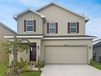 Two-story home with taupe siding and dark accents at 3744 Sagefield Dr, St Cloud, FL 34773