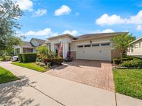 House with well-maintained landscaping, brick driveway, and a two-car garage at 4904 W Fountainwood Dr, St Cloud, FL 34772