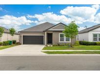 Single story home with dark brown garage door and landscaping at 1513 Playwright Dr, Deland, FL 32720