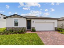 One-story house with two-car garage and brick driveway at 1167 Foreshore Ln, Haines City, FL 33844