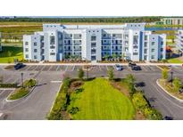 Modern apartment building with ample parking and green space at 4731 Clock Tower Dr # 101, Kissimmee, FL 34746