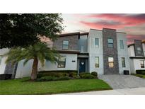 Modern three-story home with stone exterior and landscaping at 2965 Fable St, Kissimmee, FL 34746