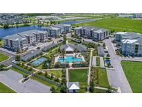 Aerial view of apartment community with pool, tennis court, and playground at 7521 Laureate Blvd # 5304, Orlando, FL 32827