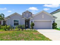Single-story home with two-car garage and landscaped yard at 875 Fillmore Ct, Davenport, FL 33837