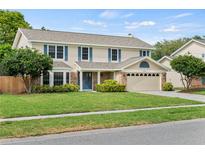 Two-story house with a brick facade, attached garage, and well-maintained lawn at 4436 Yachtmans Ct, Orlando, FL 32812