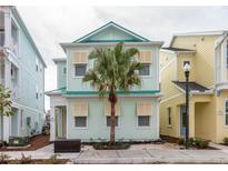 Two-story light teal home with palm tree and shutters at 8044 Shaker St, Kissimmee, FL 34747