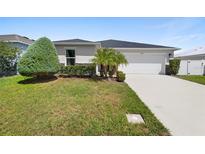 Single-story home with a two-car garage and well-manicured lawn at 2862 Mosshire Cir, Saint Cloud, FL 34772