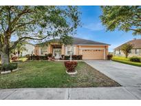One-story house with peach exterior, two car garage and lush landscaping at 4319 Dinner Lake Blvd, Lake Wales, FL 33859