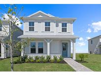 Two-story house with gray siding, white trim, and a teal door at 1970 Education St, Saint Cloud, FL 34771