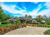 Luxury home with circular driveway and lush landscaping at 35635 High Pines Dr, Eustis, FL 32736