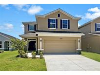 Two-story house with beige siding, dark gray shutters and a two-car garage at 3696 Sagefield Dr, Saint Cloud, FL 34773