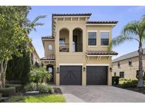 Two-story house with a two-car garage and manicured landscaping at 860 Desert Mountain Ct, Reunion, FL 34747