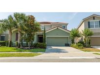 Two-story home with a two-car garage and landscaping at 7049 Oakwood St, Davenport, FL 33837