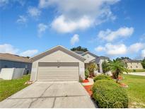 House exterior featuring a two-car garage and well-manicured landscaping at 205 Hibiscus St, Winter Haven, FL 33881