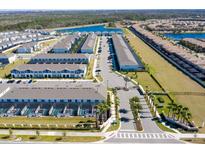 Aerial view of community with houses, lake, and roads at 2429 Dubai St, Kissimmee, FL 34747