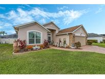 House exterior showcasing a two-car garage and well-maintained landscaping at 442 Ella Mae Dr, Davenport, FL 33897