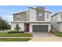 Two-story modern home with stone accents and two-car garage at 8834 Cabot Cliffs Dr, Davenport, FL 33896