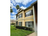 Yellow two-story building with balconies and landscaping at 5156 City St # 118, Orlando, FL 32839