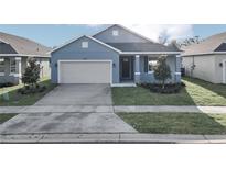 Newly built home with light blue exterior and two car garage at 530 Ellie Ct, Apopka, FL 32703