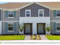 Two-story townhome with gray siding and light-colored doors at 4270 Lana Ave, Davenport, FL 33897