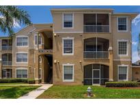 Condo building exterior with multiple units and landscaping at 8101 Coconut Palm Way # 203, Kissimmee, FL 34747