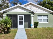 Green house exterior with a screened porch and walkway at 645 W 6Th St, Lakeland, FL 33805