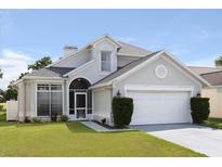 Two-story house with gray siding, white garage door and manicured lawn at 2715 Autumn Green Dr, Orlando, FL 32822
