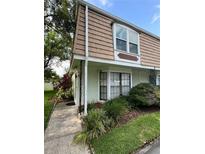 Exterior view of a townhouse with a light green facade and brown roof at 6003 Village Cir # Ge, Orlando, FL 32822
