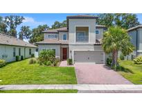 Two-story house with a gray exterior, brick driveway, and landscaping at 3860 Rose Malllow Dr, Kissimmee, FL 34746