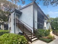 Two-story condo building with exterior stairs and lush landscaping at 232 Riverbend Dr # 201, Altamonte Springs, FL 32714
