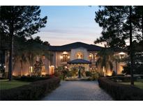 Elegant two-story home with a fountain and a brick driveway at 16716 Artimino Loop, Montverde, FL 34756