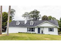 Charming ranch home with gray door and manicured lawn at 1836 Se 6Th Ave, Ocala, FL 34471