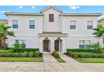 Two-story townhome with light gray siding and two-car driveway at 8984 Stinger Dr, Champions Gate, FL 33896