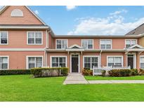 Attractive two-story townhome with a well-manicured lawn and white picket fence at 2211 San Vittorino Cir # 105, Kissimmee, FL 34741