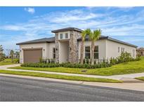 Modern one-story home with stone accents and a two-car garage at 174 Blazing Star Ave, Lake Alfred, FL 33850