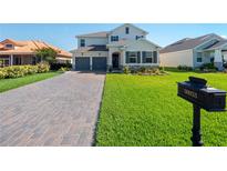 Two-story house with gray-toned garage doors and a brick driveway at 30053 Island Club Dr, Tavares, FL 32778