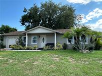 House exterior with a lawn, palm trees, and a two-car garage at 809 Florida Pkwy, Kissimmee, FL 34743