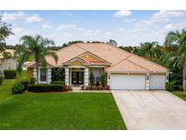 House exterior with tile roof, two-car garage, and lush landscaping at 11321 Ledgement Ln, Windermere, FL 34786