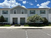 Two-story townhome with gray siding and green shutters at 8940 Sydney Ave, Kissimmee, FL 34747