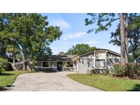 Single-story home with a gray exterior, circular driveway, and basketball hoop at 113 Ingram Cir, Longwood, FL 32779