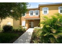 Inviting two-story townhome with landscaped walkway and lush greenery at 8516 Crystal Cove Loop, Kissimmee, FL 34747