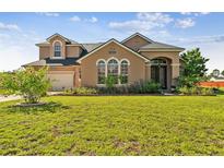 Two-story house with a large front yard, two-car garage, and landscaping at 20606 Quinn St, Orlando, FL 32833