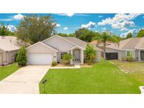 One-story home with a two-car garage and well-manicured lawn at 421 Paradise Woods Ct, Davenport, FL 33896